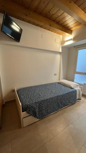 a bedroom with a bed and a tv on the wall at APARTAMENTOs URDAIBAI 1 in Bermeo