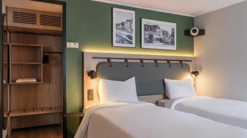 Ένα ή περισσότερα κρεβάτια σε δωμάτιο στο Campanile NATURE - Besançon Ouest Chateaufarine