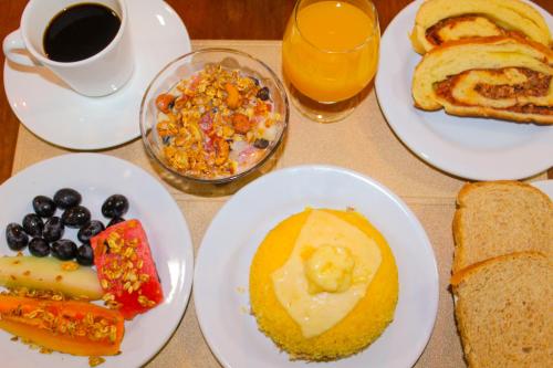 ペネドにあるHotel Rochedo, Penedo - Alagoasの食べ物の皿とコーヒーカップが置かれたテーブル