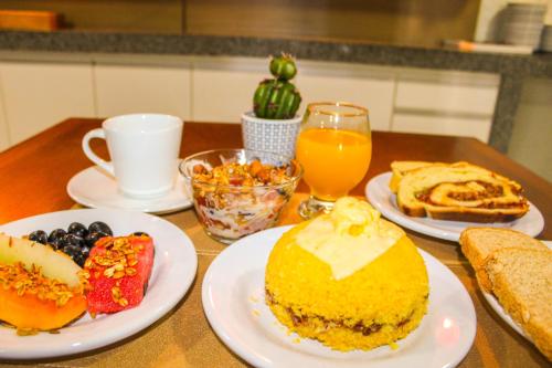 ペネドにあるHotel Rochedo, Penedo - Alagoasのテーブル(朝食用の食品、オレンジジュース付)