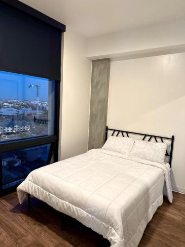 フェニックスにある2bd 2bth Highrise in the heart of Roosevelt District!の白いベッドと大きな窓のある寝室