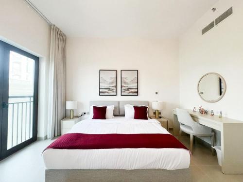 a white bedroom with a large bed and a desk at Yas Golf Elegant Studio near Ferrari World in Abu Dhabi