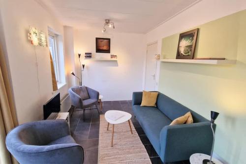 ドンブルグにあるHello Zeeland - Westweg 9Bのリビングルーム(青いソファ、椅子2脚付)