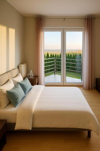 StrykowoにあるDom za Tujamiの大きなベッドと大きな窓のある寝室