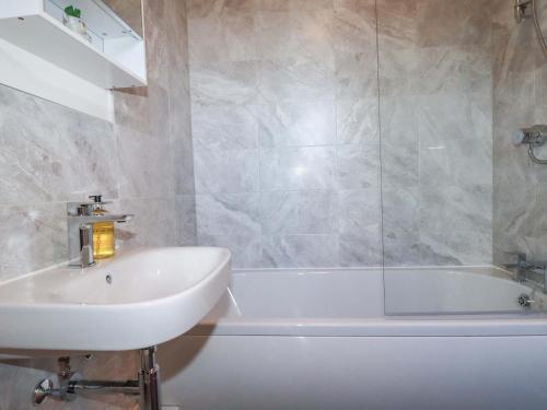 un bagno con lavandino e vasca da bagno di Yonja Homes a St Austell