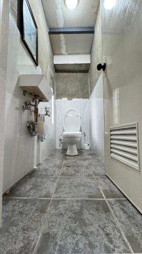 a bathroom with a toilet and a sink at TeamV Kubo Guesthouse in Agdañgan