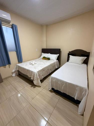 a bedroom with two beds and a window at Hotel Caribe de Alter - Alter do Chão in Santarém