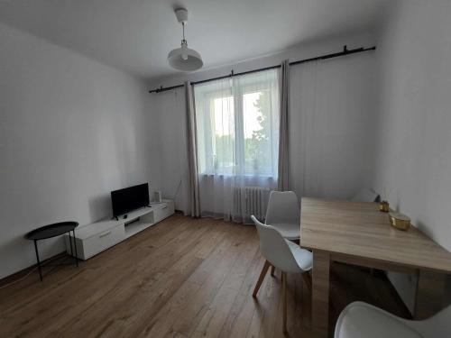 a living room with a dining table and a television at Kawalerka Krasińskiego in Kraśnik