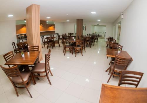 a dining room with wooden tables and chairs at Hotel Rochedo, Penedo - Alagoas in Penedo