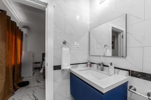 a white bathroom with a sink and a mirror at Hibiscus Charm in Red Hills