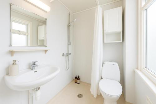 Un baño blanco con inodoro y lavabo. en Delightful Bryggen Apartment - Norwegians Minimum Age 25, en Bergen
