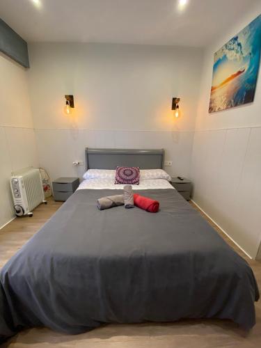 a bedroom with a large bed with a stuffed animal on it at APARTAMENTOs URDAIBAI 2 in Bermeo