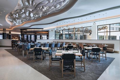 a restaurant with tables and chairs and a large ceiling at The Westin Dallas Southlake in Southlake
