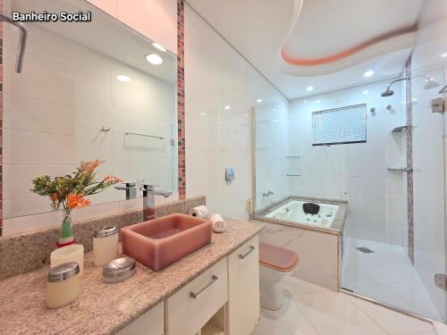 een badkamer met een roze wastafel en een douche bij Luxury and Comfort, Jacuzzi, Spectacular Pool in Foz do Iguaçu