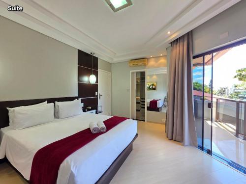 een slaapkamer met een groot bed en een balkon bij Luxury and Comfort, Jacuzzi, Spectacular Pool in Foz do Iguaçu