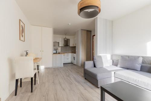 a white living room with a couch and a table at Le petit Taison - Metz Hyper center in Metz