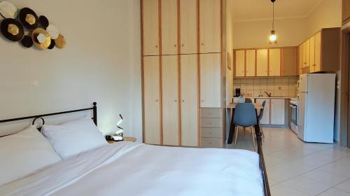a bedroom with a white bed and a kitchen at Mountain View Apartments in Kalavrita