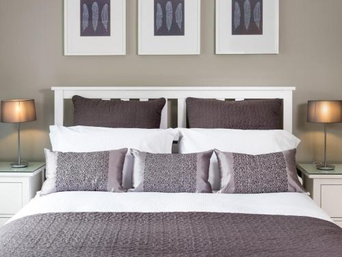 a bedroom with a white bed with pillows and two lamps at 4 Bed in Borrowdale SZ219 in Grange