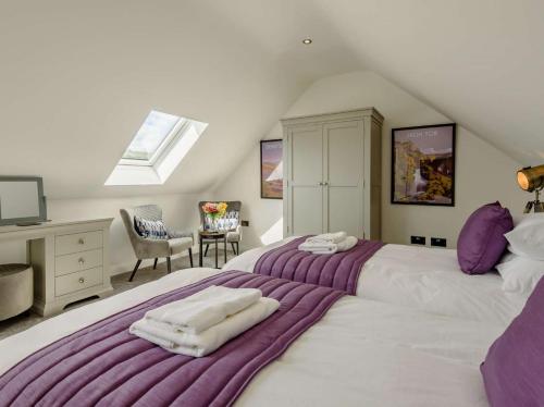two beds in a attic bedroom with purple and white sheets at 4 Bed in Bradwell 89431 in Bradwell