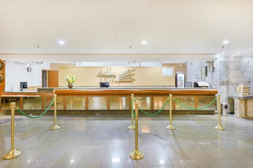 a lobby with a counter with yellow ropes at Hotel Nacional Inn Campinas Trevo in Campinas