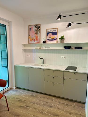 a kitchen with white cabinets and a sink at City-Centre appartment in Piešťany