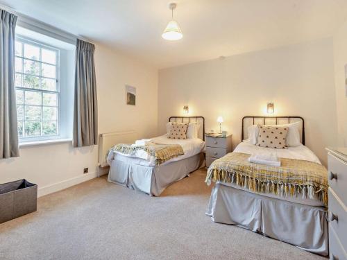 a bedroom with two beds and a window at 3 Bed in Braithwaite SZ174 in Braithwaite