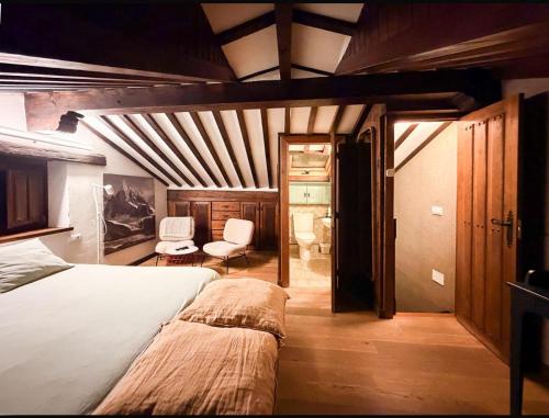 een slaapkamer met een bed en een stoel erin bij LITTLE TOWER in Potes