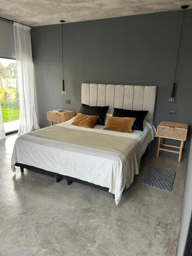 a bedroom with a large bed with two chairs at Casa Rumenco Joven mdq in Mar del Plata