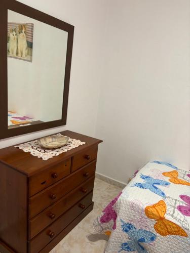 a bedroom with a dresser with a mirror and a bed at Roque Blanco in Frontera