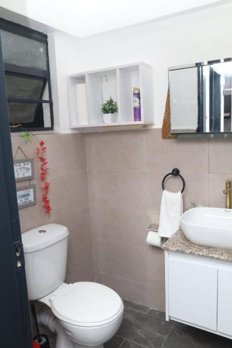 a bathroom with a toilet and a sink at Makasembo Cozy Serenity in Kisumu