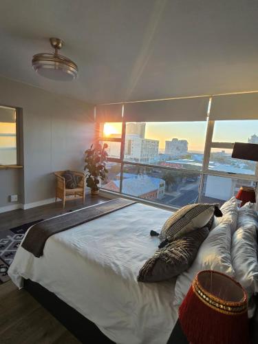 a large bed in a room with a large window at Panorama Sea and Mountain Views in Strand