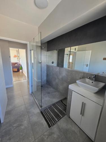 a bathroom with a sink and a glass shower at Panorama Sea and Mountain Views in Strand