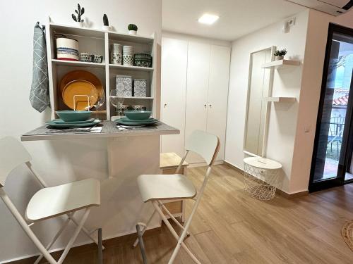 cocina con encimera y sillas en una habitación en Refúgio junto à falésia, en Olhos de Água