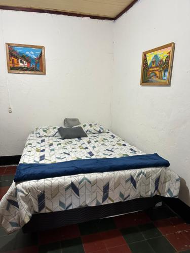1 cama en una habitación con 2 cuadros en la pared en Paseo Antigua, en Antigua Guatemala