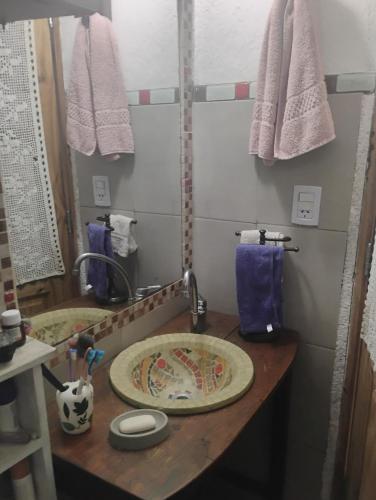 ein Badezimmer mit einer Theke mit einem Waschbecken und Handtüchern in der Unterkunft Casa de campo con pileta in Alta Gracia