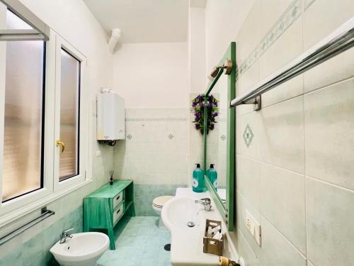 a white bathroom with a sink and a toilet at Be Your Home - Casa Vacanze Il Posticino in Civitavecchia