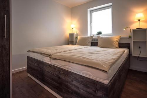 a large bed in a room with a window at Deichkoje 2 Dagebüll in Dagebüll