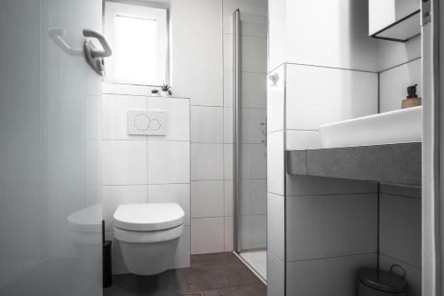 a white bathroom with a toilet and a sink at Deichkoje 2 Dagebüll in Dagebüll