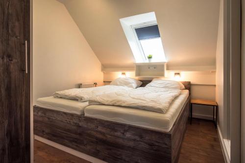 a bedroom with a bed with a window above it at Deichkoje 4 Dagebüll in Dagebüll