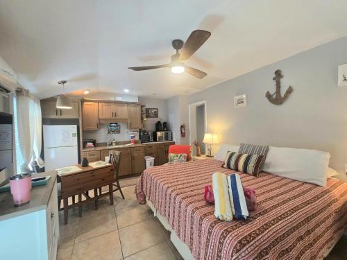 a bedroom with a large bed and a kitchen at An Island Getaway at Palm Tree Villas in Holmes Beach