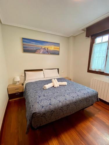 een slaapkamer met een bed met twee handdoeken erop bij APARTAMENTOS URDAIBAI 7 in Bermeo