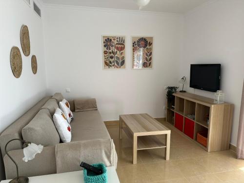 a living room with a couch and a tv at Pegaso II in San Juan de los Terreros