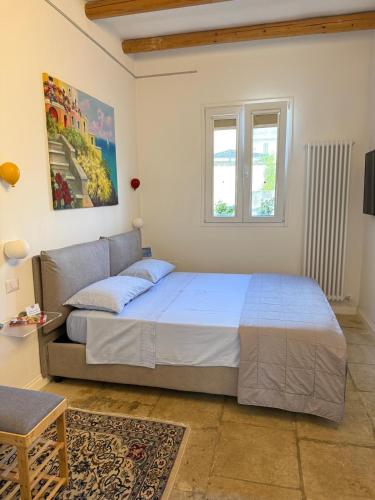 a bedroom with a bed and a couch and a window at Suite Battisti 7 in Lecce