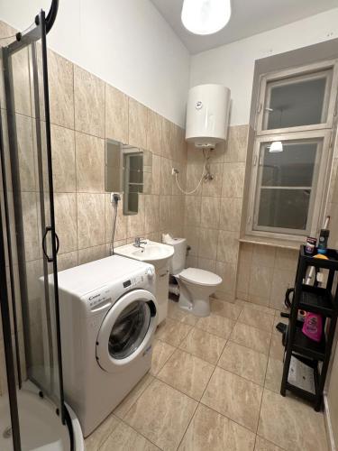 een badkamer met wasmachine en toilet bij Pokoje przy Rynku IV in Katowice
