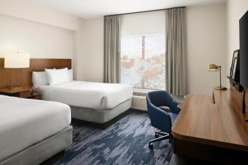 a hotel room with two beds and a desk at Fairfield Inn & Suites by Marriott Newark Liberty International Airport in Newark