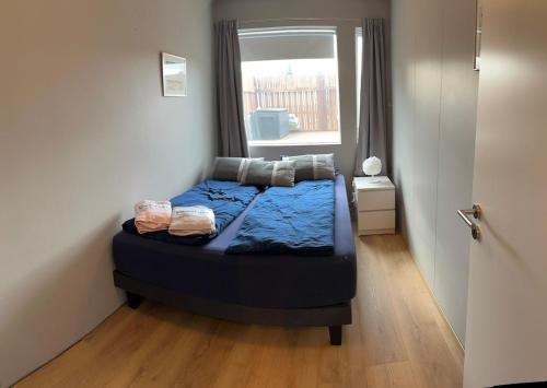 a small bed in a room with a window at Two rooms apartment in Reykjavik in Reykjavík