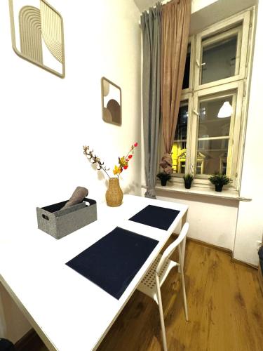a white table and chairs in a room with a window at Pokoje przy Rynku III in Katowice