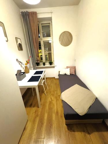 a small room with a bed and a desk at Pokoje przy Rynku III in Katowice