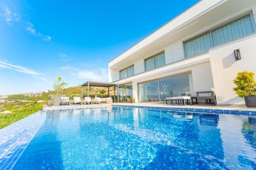 an image of a swimming pool in front of a house at Lê Maison Deluxe Madeira - Where Peace is breathed and Luxury is felt! in Ribeira Brava