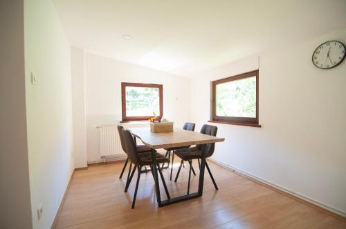 a dining room with a table and chairs and a clock at Grunthouse in Prebold